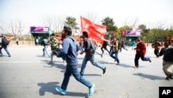 Members of a splinter faction of the Unified Communist Party of Nepal Maoist run and shout slogans as they protest against the formation of an interim government in Katmandu, Nepal, March 14, 2013.