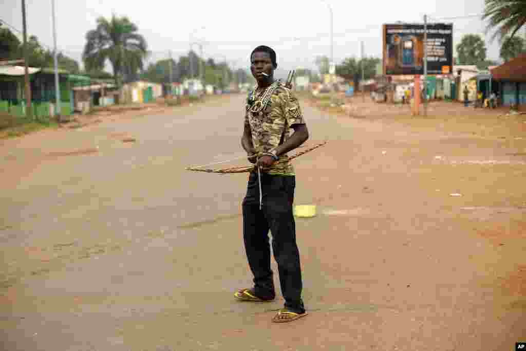 An anti-Balaka Christian militiaman holding a bow and arrow stands in, what days before, was a predominantly Muslim area of the Miskin district of Bangui, Feb. 4, 2014. 