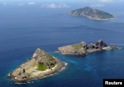 FILE - A group of disputed islands, Uotsuri island (top), Minamikojima (bottom) and Kitakojima, known as Senkaku in Japan and Diaoyu in China is seen in the East China Sea, in this photo taken by Kyodo September 2012.