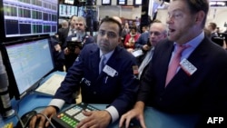 ນັກຊ່ຽວຊານ ທ່ານ Dilip Patel, ຊ້າຍ, ແລະ ທ່ານ Patrick Murphy ເຮັດວຽກໃນຕະຫຼາດຮຸ້ນໃນນະຄອນ New York Stock Exchange, 25 ມັງກອນ, 2017. 