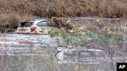 Two vehicles amid debris of a flooded area of ​​Highway 7 west of Agassiz, British Columbia, Canada, Nov. 20, 2021.