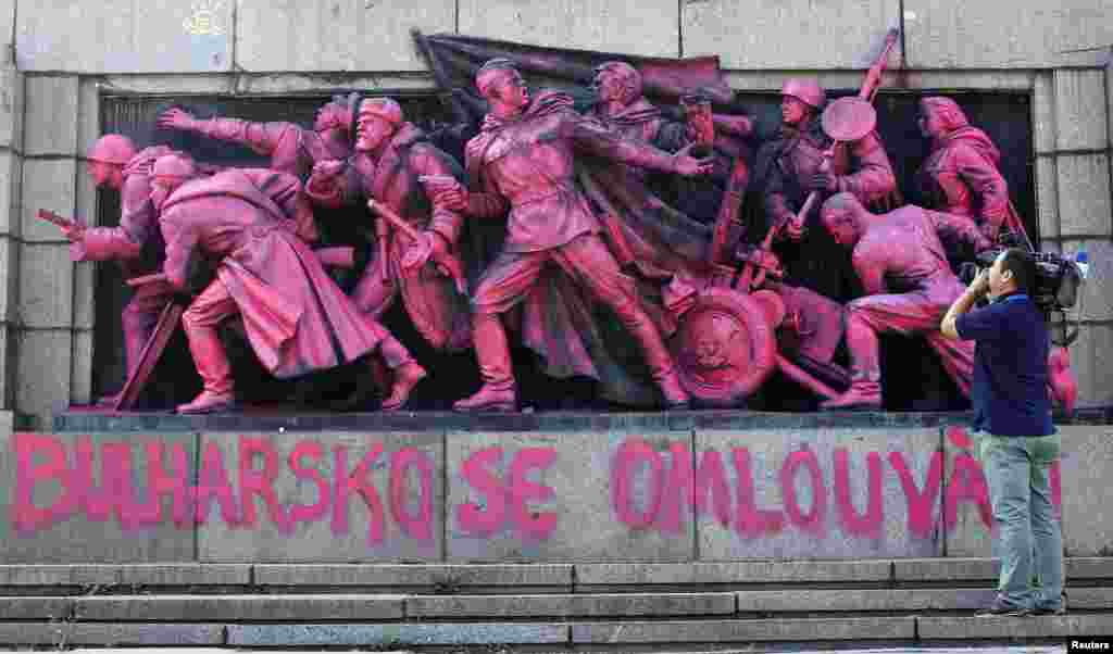 A cameraman films the figures of Soviet soldiers at the base of the Soviet Army monument painted in pink in Sofia. Unknown artists have painted the nine soldiers in pink during the night and wrote &quot;Bulgaria apologizes&quot; both in Bulgarian and Czech language in what appears to be an artistic apology for Bulgaria&#39;s support in smashing the Prague Spring uprising against the Communist rule on August 20-21, 1968.