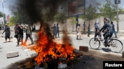 Afghan protesters set a fire during a protest in Kabul, Afghanistan, June 2, 2017. A rally against the government Friday following Wednesday’s devastating truck bomb attack in Kabul saw hours of angry confrontation between protesters and police.