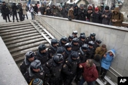 Police officers block the path of people intending to attend an opposition rally in Pushkin Square in Moscow, Russia, Dec. 12, 2015.