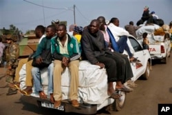 FILE - At PK12, the last checkpoint at the exit of the town, thousands of Muslim residents from Bangui and Mbaiki flee the Central African Republic capital Bangui in a mass exodus using cars, pickups, trucks, lorries and motorcycles, escorted by Chadian troops,