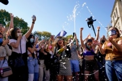 Amanda Madden sprays champagne as people celebrate at Black Lives Matter Plaza with the news of Democratic presidential candidate Joe Biden winning over Pres. Donald Trump to become the 46th president of the United States.