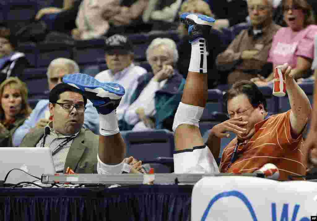 Connecticut's Kaleena Mosqueda-Lewis, center, chases a ball out of bounds, falling between Hartford Courant writer John Altavilla, left, and Associated Press freelancer Ken Davis, right, during the second half of an NCAA college exhibition basketball game in Storrs, Connecticut, USA, Nov. 1, 2013.