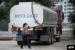 FILE- A petrol station worker walks past a fuel truck in Pyongyang, July 21, 2017.