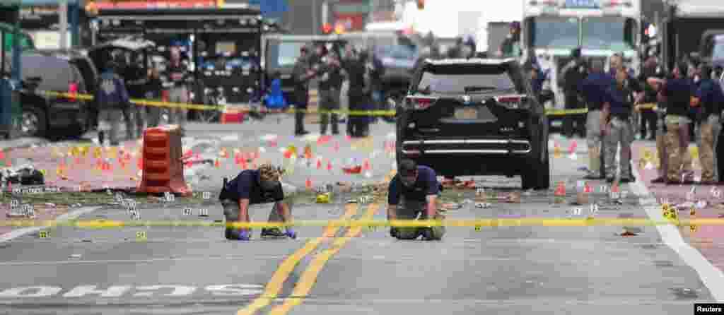 Agentes da polícia federal, americana, FBI, marcam o local onde se registou a explosão de sábado passado no bairro de Chelsea em Nova Iorque , que causou ferimentos em 29 pessoas.