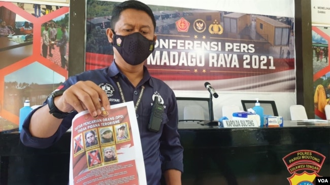 Petugas memperlihatkan foto dan nama dari 4 teroris sisa anggota kelompok Mujahidin Indonesia Timur (MIT) yang masih diburu, Minggu (19/9/2021) (foto: VOA/Yoanes Litha).