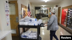 Petugas pemungutan suara Sharon Krewson mendorong troli berisi surat suara yang sudah selesai setelah Hari Pemilu di Gedung Balai Kota Kenosha, di Kenosha, Wisconsin, AS, Rabu, 4 November 2020.