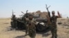 مبارزان مسلح شیعه عراق، در کنار یک تانک منهدم شده متعلق به گروه «دولت اسلامی» پس از شکستن حصر آمرلی 