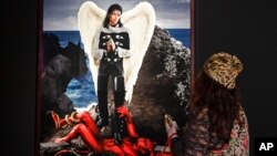 A visitor watches the picture 'Archangel Michael: And no message could have been any clearer' from US artist David LaChapelle at a preview of the exhibition 'Michael Jackson: On The Wall' at the Bundeskunsthalle museum in Bonn, Germany, March 21, 2019. 