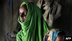 A handout photograph taken on April 15, 2013 and released 16 by the African Union-United Nations Information Support Team shows a Somali woman holding her child at a clinic run by the Burundian contingent of the African Union Mission in Somalia.