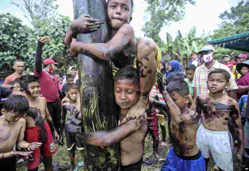 Children take part in a greased-pole climbing competition during the celebration of the 75th anniversary of the country&#39;s independence in Medan, North Sumatra, Indonesia.
