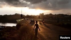 A boy stands on a road at dawn in Freetown, Sierra Leone, November 2012.