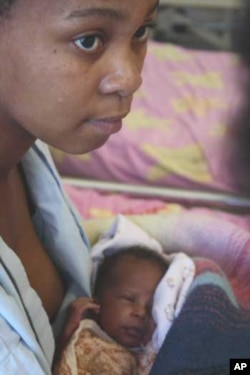 A mother with her newborn baby listens to advice from a nurse in a hospital in South Africa, which has a very high infant mortality rate