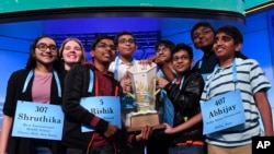 The eight co-champions of the 2019 Scripps National Spelling Bee hold the trophy at the end of the competition in Oxon Hill, Md., May 31, 2019.