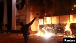 Kiev'de yanan polis aracına havai fişek atan bir gösterici