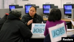 FILE - A case worker talks to job seekers at a San Francisco employment center.