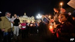 People hold candles as they attend a prayer vigil for terminally ill toddler Alfie Evans, in St. Peter's Square at the Vatican, Thursday, April 26, 2018.