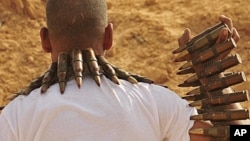 A rebel fighter carries large caliber ammunition on the front line, 18 km (11 miles) west of Ajdabiyah, Libya, June 27, 2011