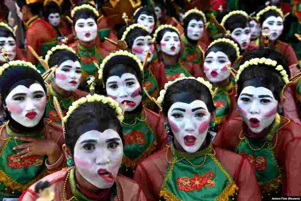 Dancers reacts to camera before they perform a Thengul dance during a festival in Bojonegoro, East Java province, Indonesia.