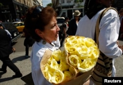 A woman carries a bouquet of yellow flowers to the Palace of Fine Arts where the ashes of Colombian Nobel Prize laureate Gabriel Garcia Marquez will be displayed in Mexico City, April 21, 2014.