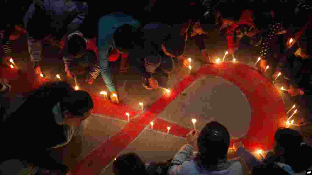 Des femmes et les enfants népalais de "Maiti Nepal", un centre de réadaptation pour les victimes de trafic sexuel, allument des bougies à Katmandou, au Népal, 30 novembre 2015. 