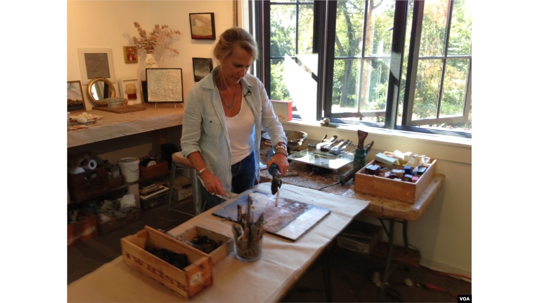 Georgia Nassikas paints in encaustic at her studio in McLean, Virginia, Sept. 17, 2015. (VOA / J. Taboh)