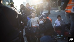 Un policía israelí y paramedicos atienden a uno de los heridos en la escena del acuchillamiento en un bus del Tel Aviv.