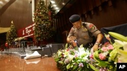 Members of a police bomb squad search for suspicious materials prior to the Christmas Eve Mass at the Messiah Cathedral in Jakarta, Indonesia, Dec. 24, 2014.