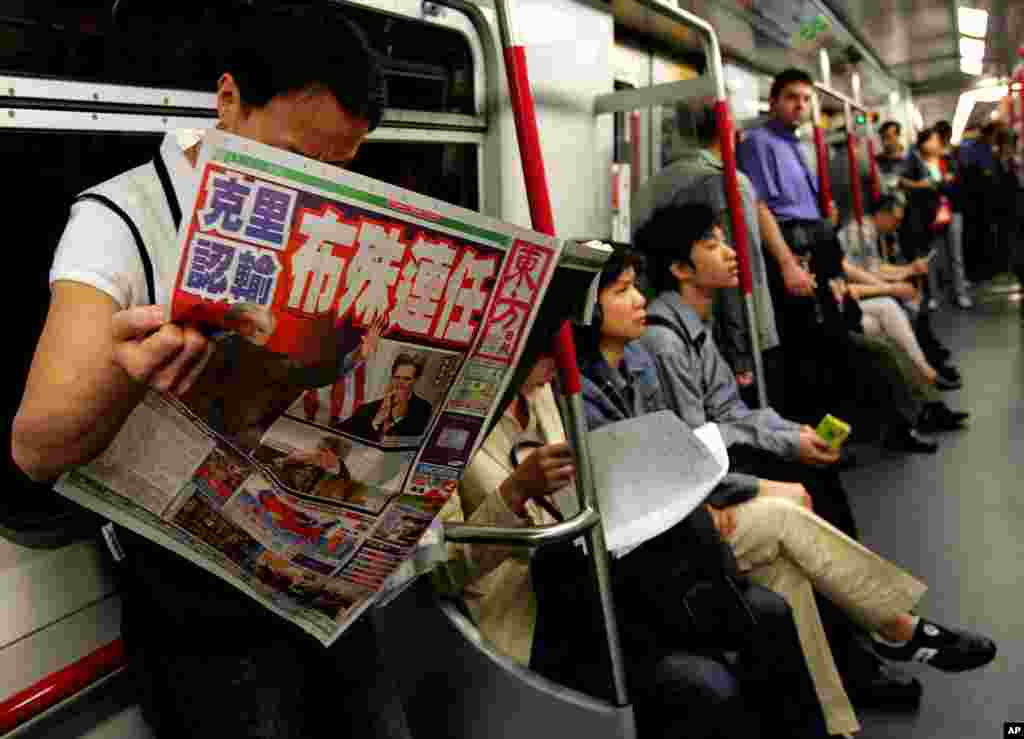Un homme lisant un article de journal sur les &eacute;lections am&eacute;ricaines dans le m&eacute;tro de Hong Kong 