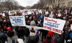 FILE - Protesters carry signs and chant on Pennsylvania Avenue near the White House during a demonstration to denounce President Donald Trump's executive order that bars citizens of seven predominantly Muslim-majority countries from entering the U.S.