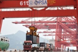 FILE - A crane loads a container onto a truck at Lianyungang Port in Lianyungang in China's eastern Jiangsu province on Sept. 7, 2021.