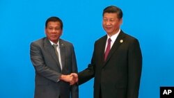 Chinese President Xi Jinping, right, shakes hands with Philippines President Rodrigo Duterte as they attend the welcome ceremony at Yanqi Lake during the Belt and Road Forum, in Beijing, China, Monday, May 15, 2017. (Roman Pilipey/Pool Photo via AP)