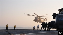 MH-53 helicopters land aboard the amphibious dock landing ship USS Tortuga (LSD 46) in the Sea of Japan, March 12, 2011