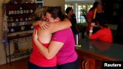 FILE - Natalie Pereira, center, cries as she embraces her sister-in-law before her move to the U.S. after winning the green card lottery, at their home in Valencia, Venezuela, April 6, 2014. 