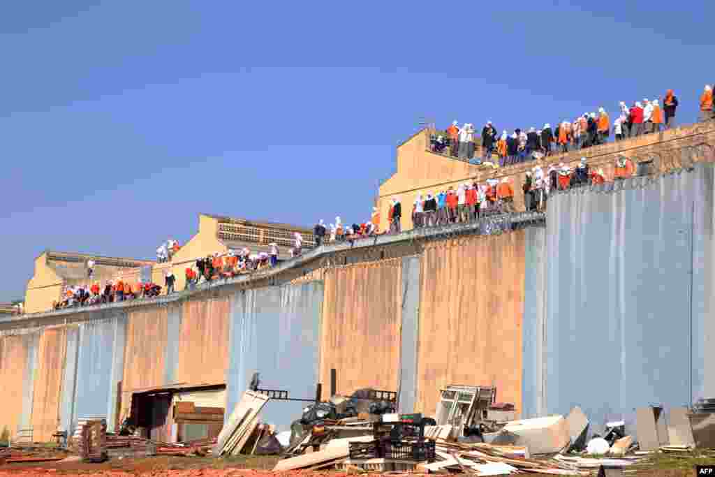 Inmates stand on the roof of the penitentiary in Cascavel, Parana state, Brazil. Inmates rioting for better facilities in a jail killed four fellow prisoners, decapitating two of them, and took two guards hostage, officials said.