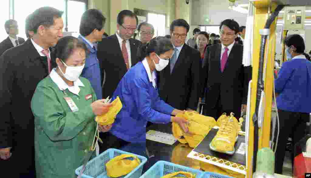 Ahn Hong-joon, chairman of the South Korean National Assembly's Foreign Affairs and Unification Committee and lawmakers look at North Korean workers during their visit to a factory in the inter-Korean industrial park in Kaesong, North Korea, Oct. 30, 2013