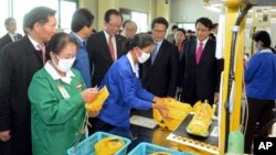 Ahn Hong-joon, chairman of the South Korean National Assembly's Foreign Affairs and Unification Committee and lawmakers watch North Korean workers during a visit to a factory in the inter-Korean industrial park in Kaesong, North Korea, Oct. 30, 2013.