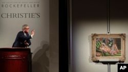 Global president of Christie's Jussi Pylkkanen taps the gavel on the podium for the final sale of Henri Matisse's "Odalisque couchee aux magnolias" for $71.5 million during an auction from the collection of Peggy and David Rockefeller, May 8, 2018, in New York.