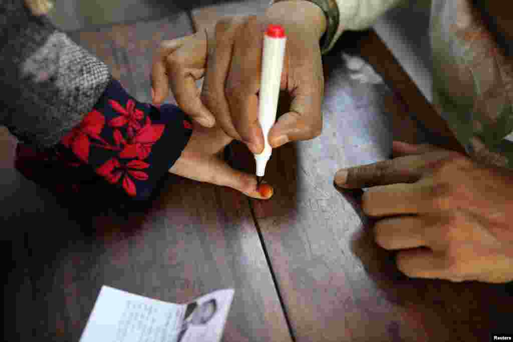 ایک خاتون ووٹر کو سیاہی کا نشان لگایا جا رہا ہے۔