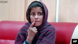 Ten-year-old Afghan girl Spozhmai sits at a police station after telling police her brother put a suicide bomb vest on her but she refused to blow herself up, Khan Neshin, Helmand, Afghanistan, Jan. 6, 2014.