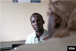 Ibrahim Hussein, a father of seven, is taken through the repatriation by an UNHCR representative, Dadaab, Kenya, April 27, 2015. (Mohammed Yusuf/VOA).