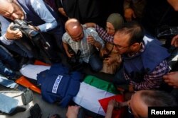 Para pelayat, termasuk wartawan, bereaksi di sebelah mayat reporter Al-Jazeera Shireen Abu Akleh, yang terbunuh oleh tembakan tentara Israel, di Jenin di Tepi Barat yang diduduki Israel. (Foto: Reuters)