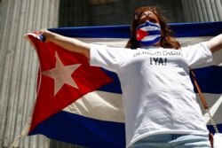 A woman holds a Cuban flag during a demonstration in support of anti-government protests in Cuba, in front of the Spanish parliament in Madrid, Spain, July 12, 2021.
