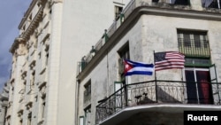 Cuban and U.S. flags are seen on the balcony of a restaurant in Havana, Cuba, March 19, 2016. 