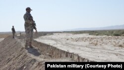 Pakistani soldiers stand guard near the trench near the Afghanistan border.