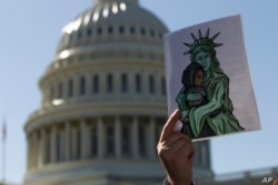 Un activista muestra una imagen a favor de los refugiados durante una manifestación frente al Capitolio de los EE. UU. En Washington, el 15 de octubre de 2019.